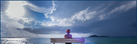 Coface-Studie: Die Zahlungsmoral lässt nach. Das Bild zeigt eien Frau auf einer Bank, am Horizont ziehen dunkle Wolken auf.